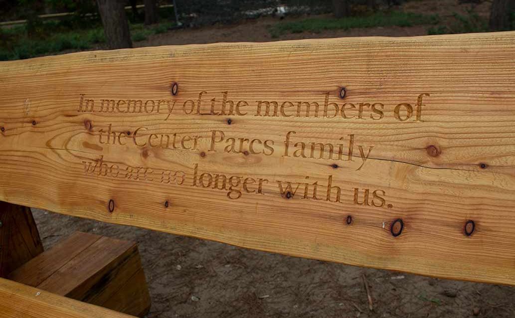 An inscription on a bench reading "In memory of the members of the Center Parcs family who are no longer with us."