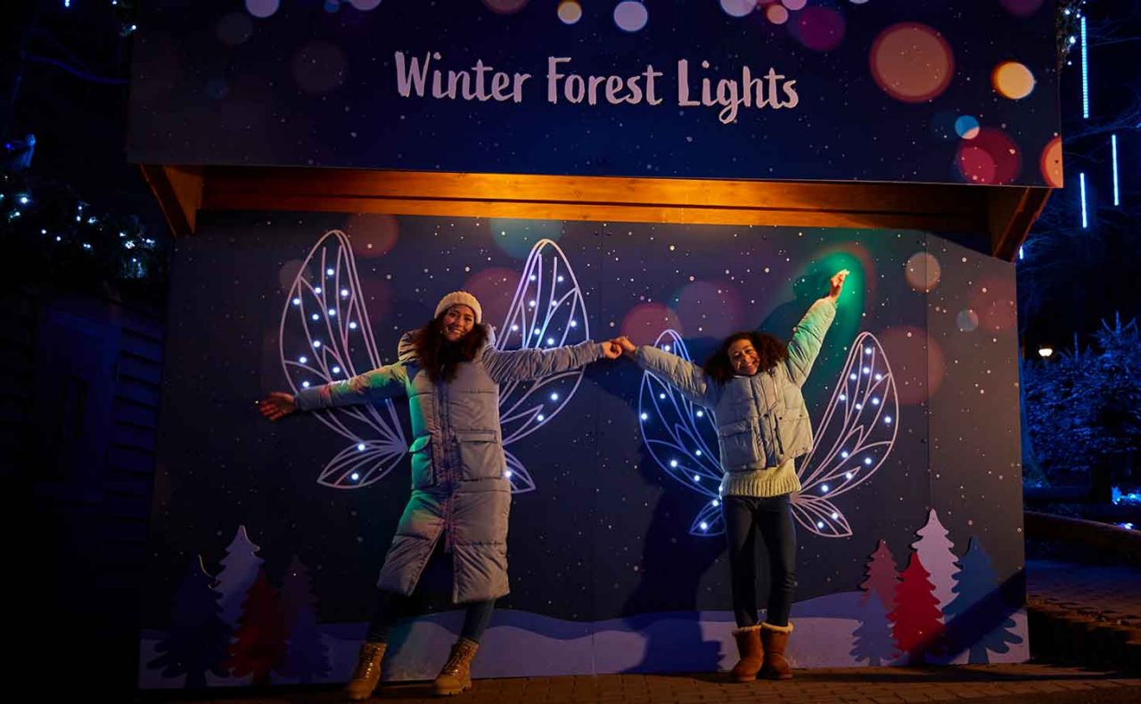 mum and daughter posing in front of photo opportunity with twinkling wings