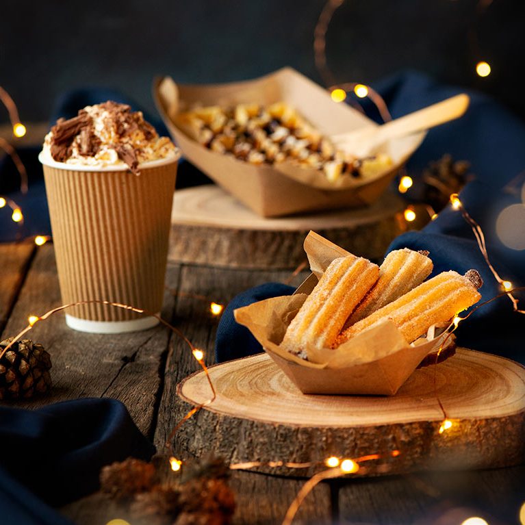 A plate of Churros with a hot chocolate with cream and flake 