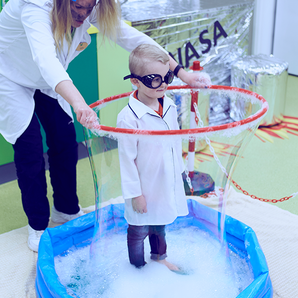 Child inside a soap bubble hoola hoop experiment