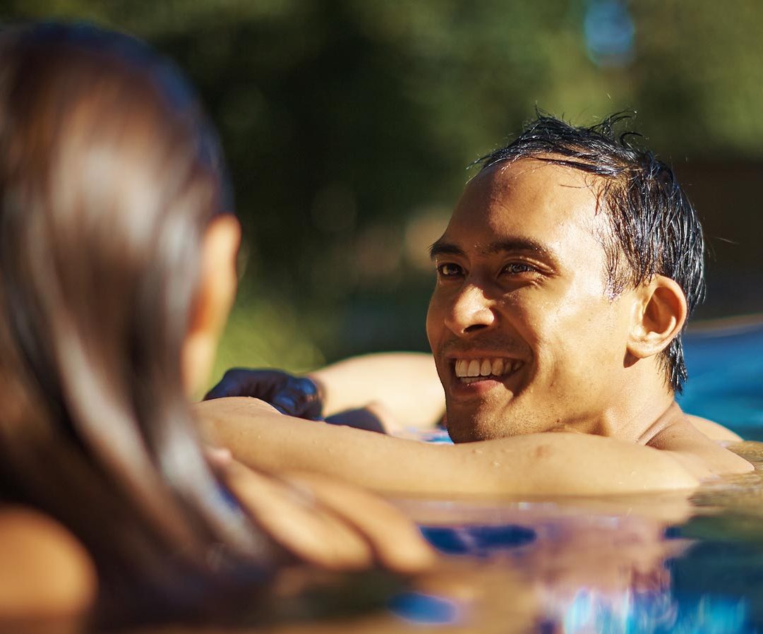 A couple enjoying a swim in the outdoor pool at Aqua Sana Spa
