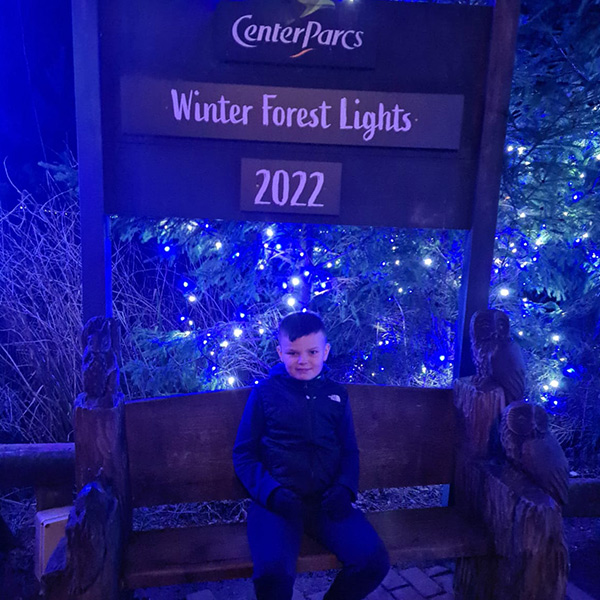 young-boy-sat-on-bench-with-twinkling-blue-lights-around
