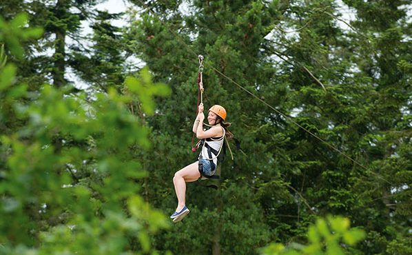 Girl on zip-wire through the forest
