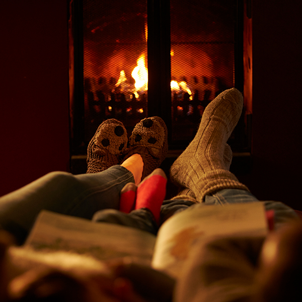 Couples feet warming in front of the fire