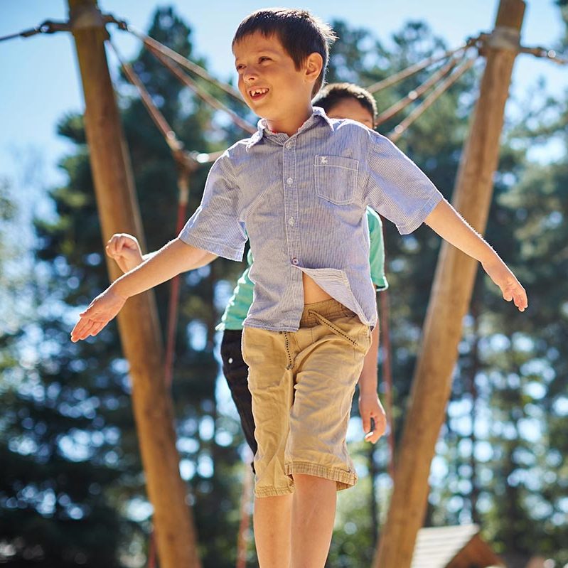 Two children balancing on a beam at the Adventure Playground