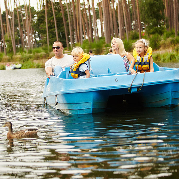 A family of 4 cruise around the lake on a Pedalo