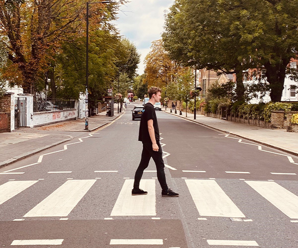 A photo of Elliot walking across a zebra crossing