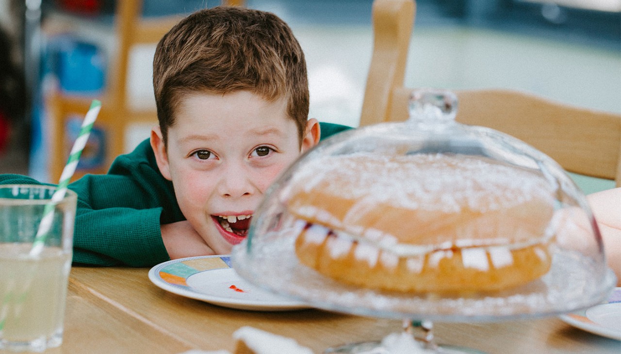 Young boy, Nicholas, smiling with a cake next to him 