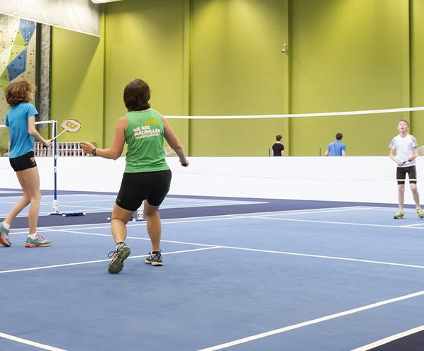 People playing badminton in an inside court