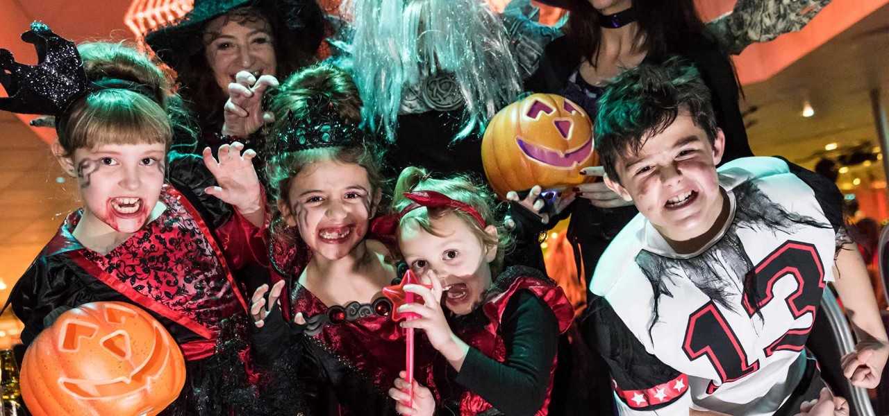 Children dressed up in Halloween costumes pulling faces at the camera