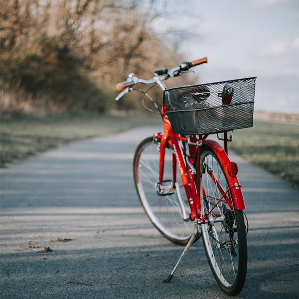 A red bike with a basket on an empty path.