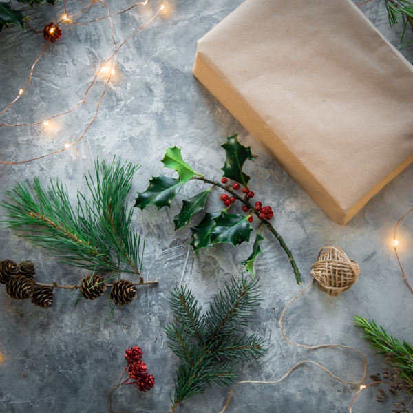Gifts in brown paper surrounded holly and mistletoe