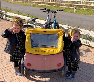 two-little-girls-posing-next-to-cycle-trailer