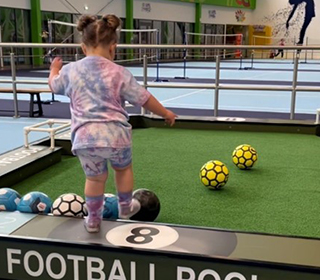 little-girl-kicking-a-football-in-an-activity