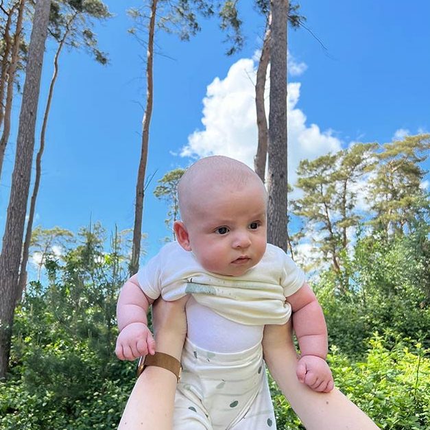 Wilf at 3 months old being held up among the trees