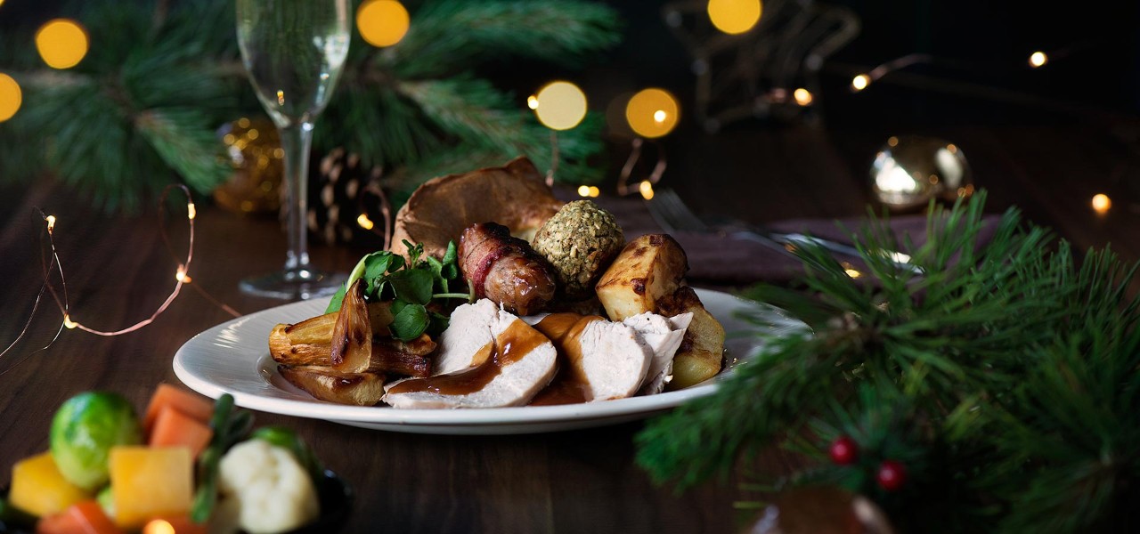 A roast dinner with gravy surrounded by Christmas decorations