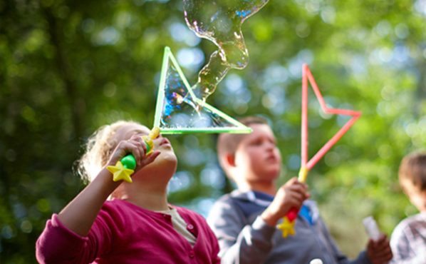 Children blowing bubbles outdoors.