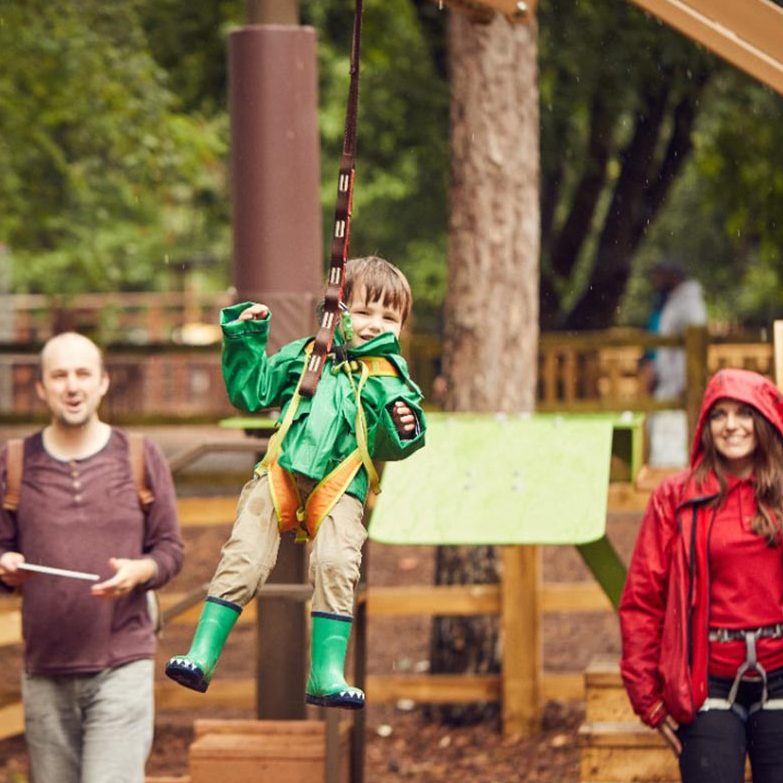 Little boy rides the Mini Trek Zipwire with Dad and Instructor 