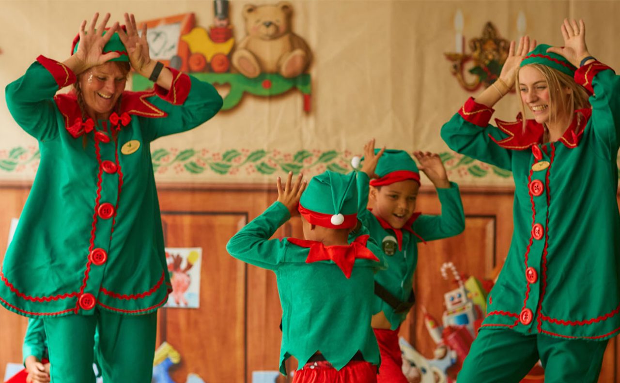 Children having fun on a festive activity dressed as elves and dancing