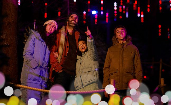 Mesmerised family in Enchanted Light Garden and young girl pointing at lights