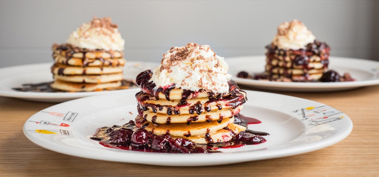 Stack of pancakes with berries and cream