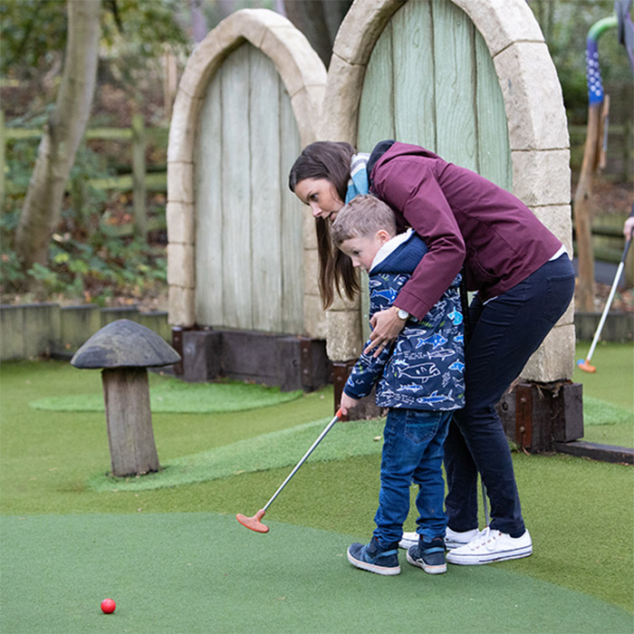 Mother and son playing mini golf