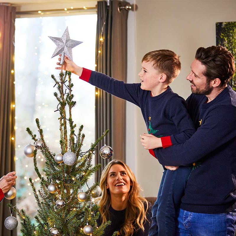Family decorating a Christmas tree together