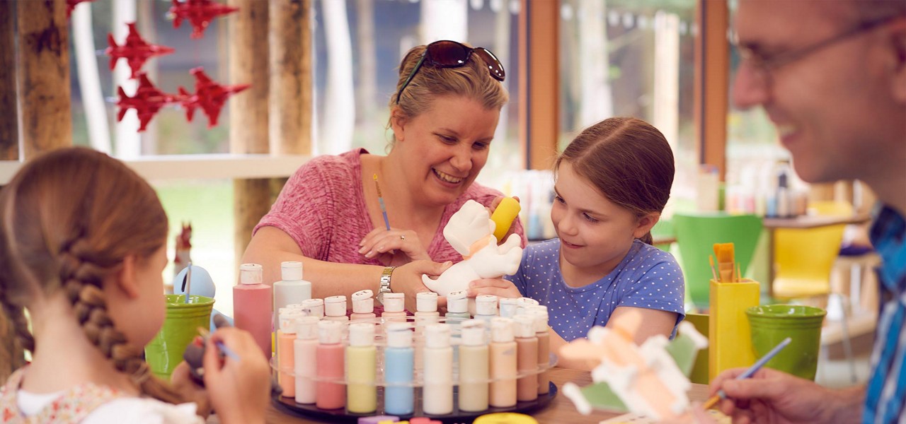 Family painting a pottery dog