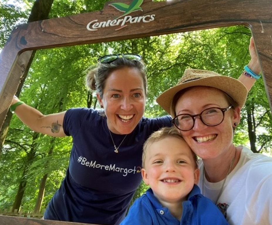A little boy and his parents pose for a photo together behind a Center Parcs photo frame