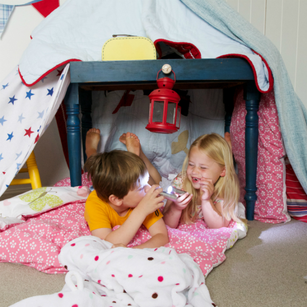 Children with torch playing in a den
