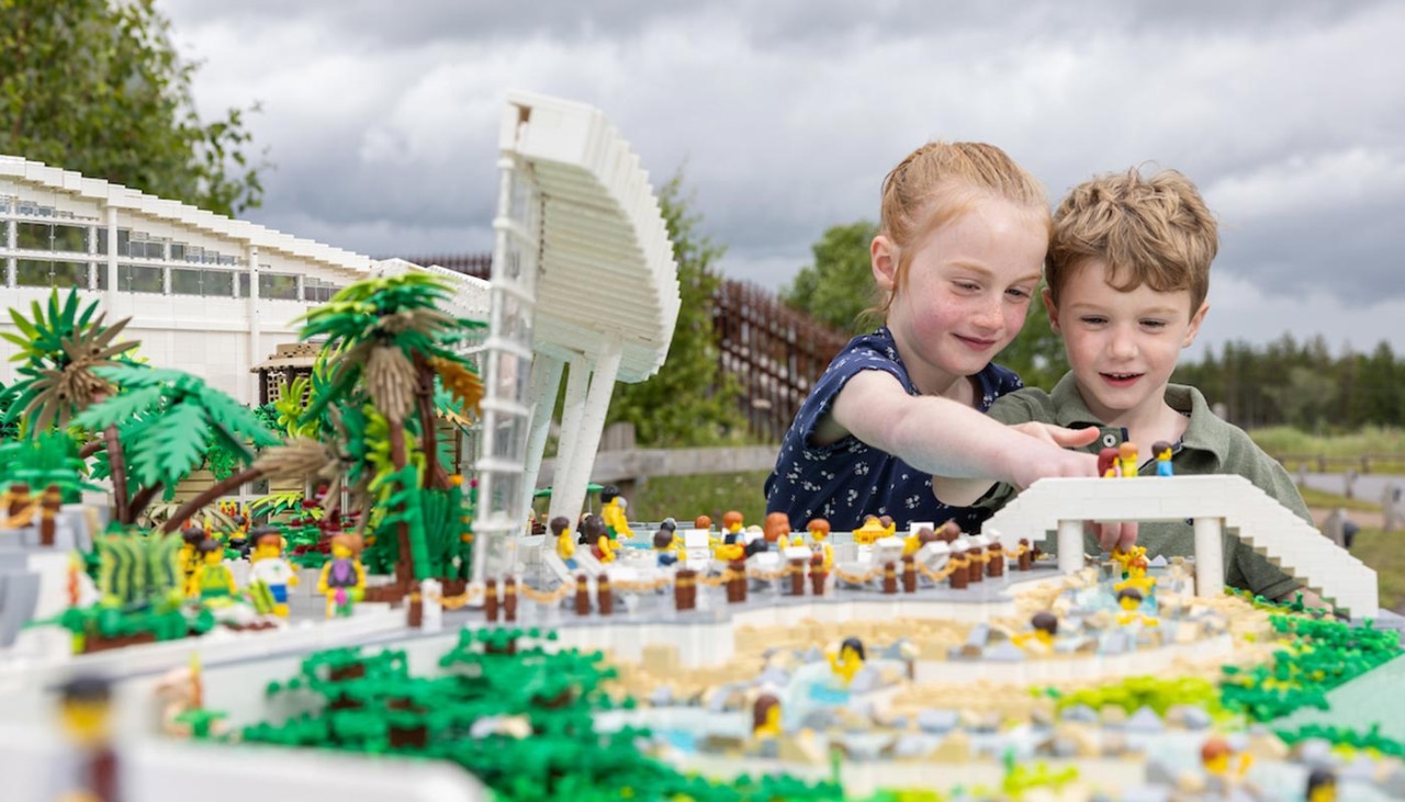 A girl and boy play with a Lego model of Longford Forest