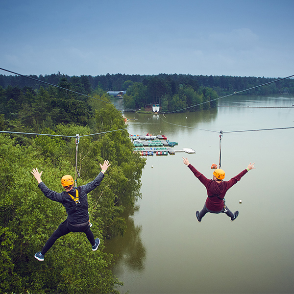 Pair on a zipwire across the lake