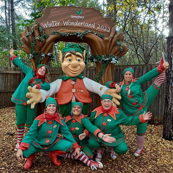 a group of elves posing infront of an elf sculpture 