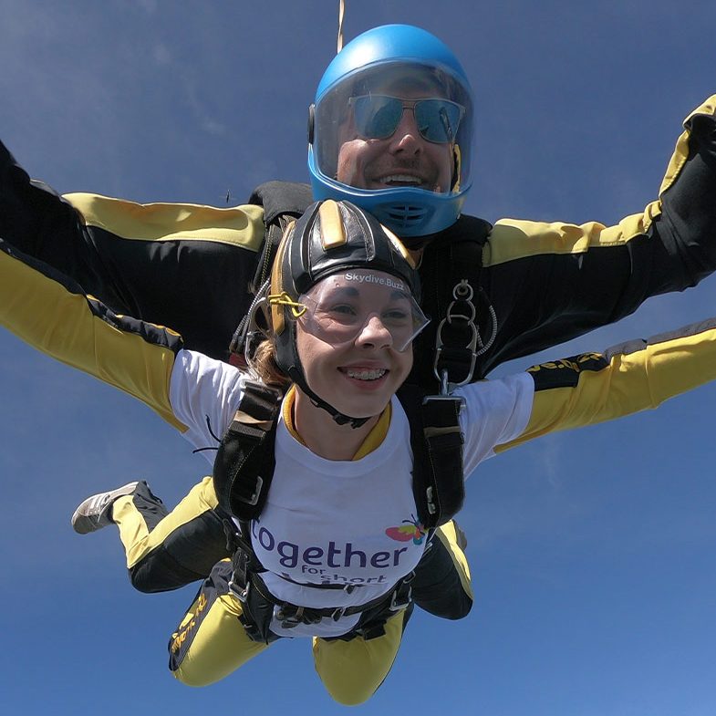 Fundraiser smiling while skydiving 