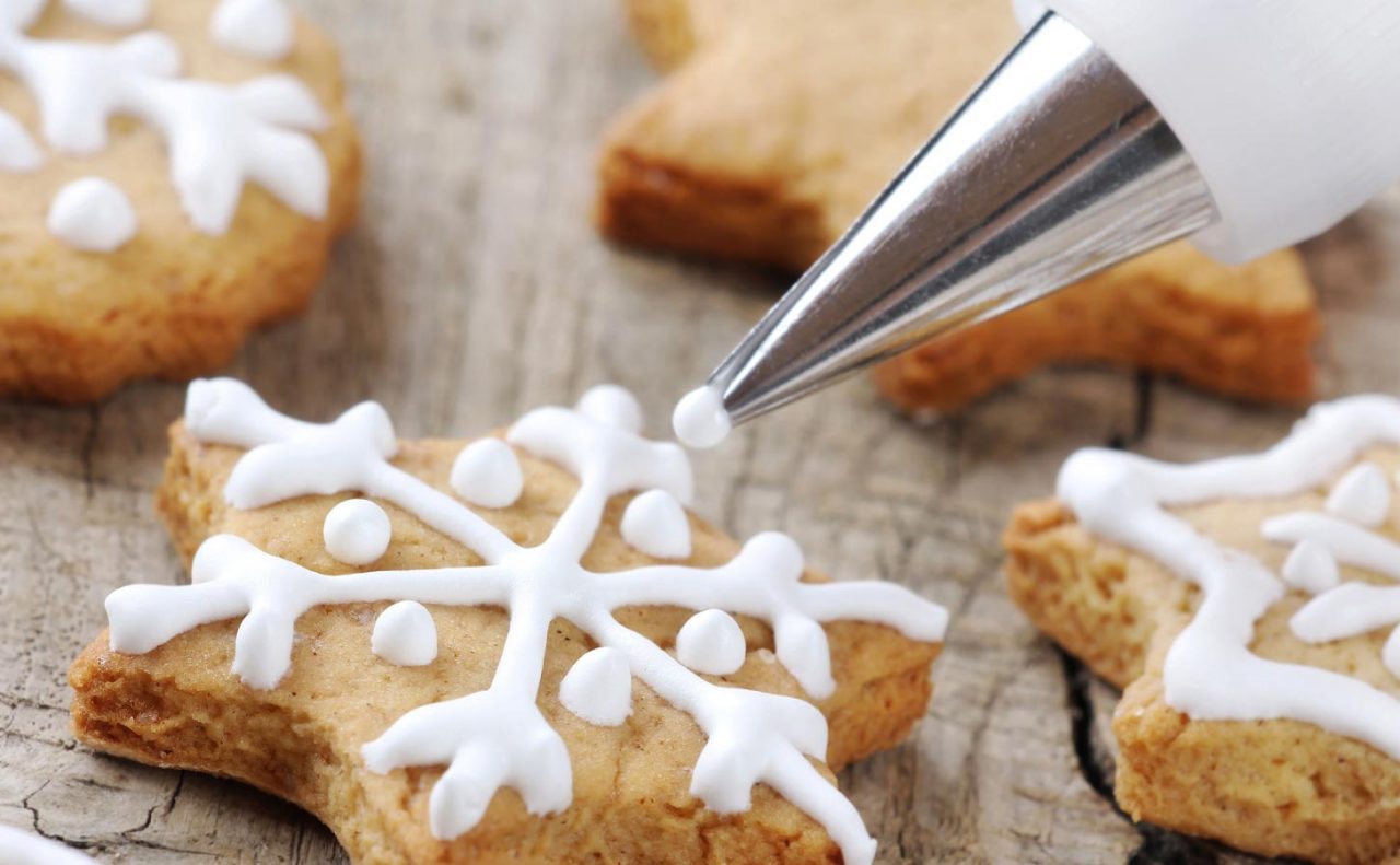 Close up of a winter shaped cookie with white piped icing to decorate 