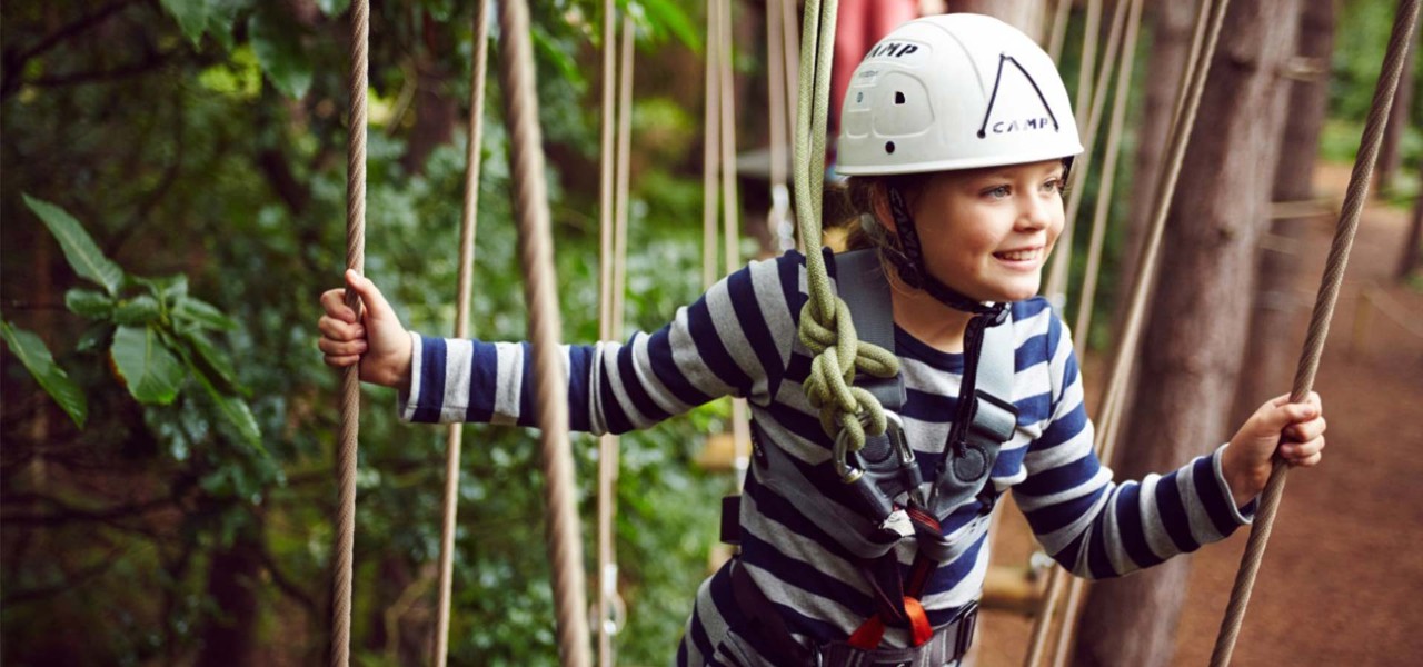 A little girl takes to the trees in Aerial Adventure