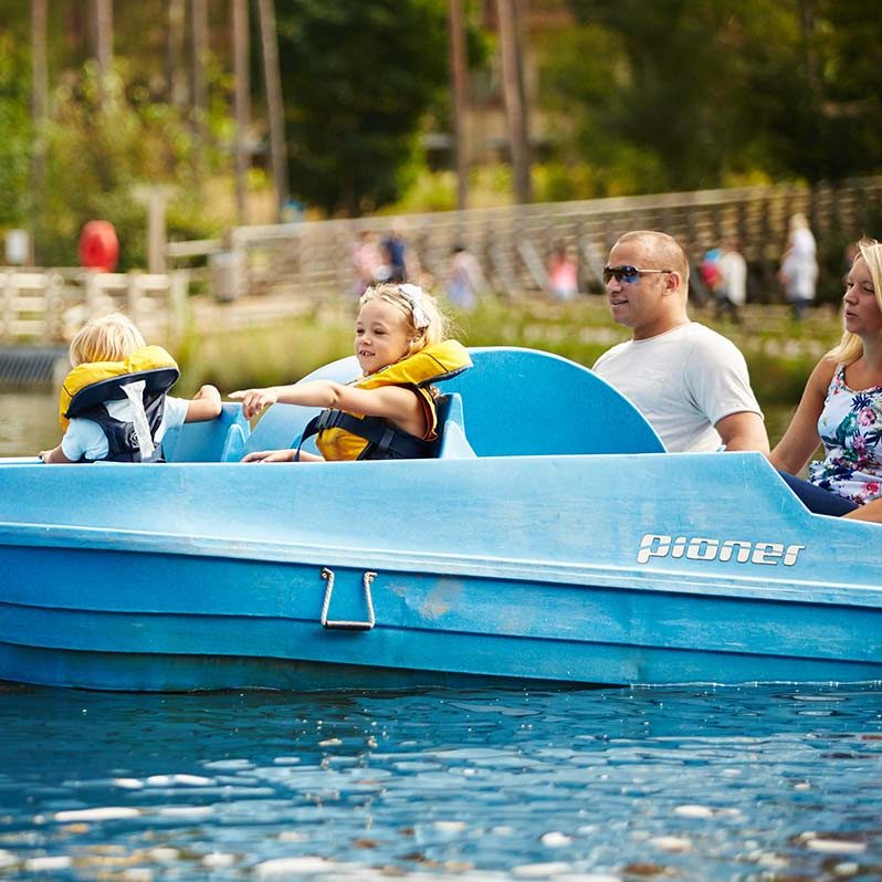 A family of 4 cruise around the lake on a Pedalo