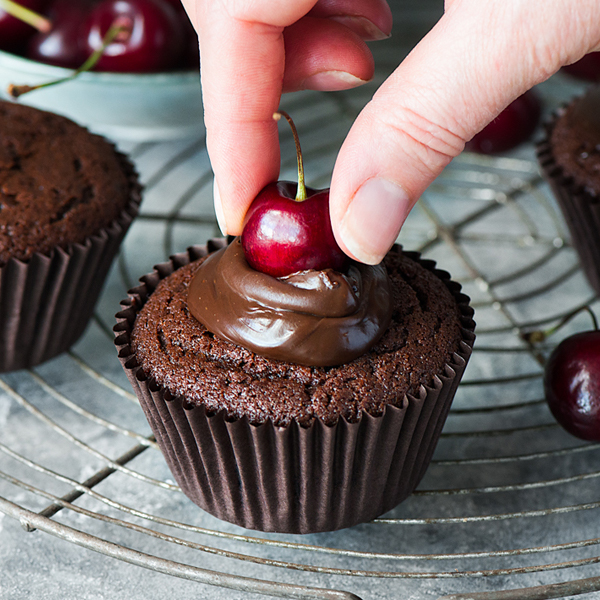Placing a cherry on the chocolate muffins