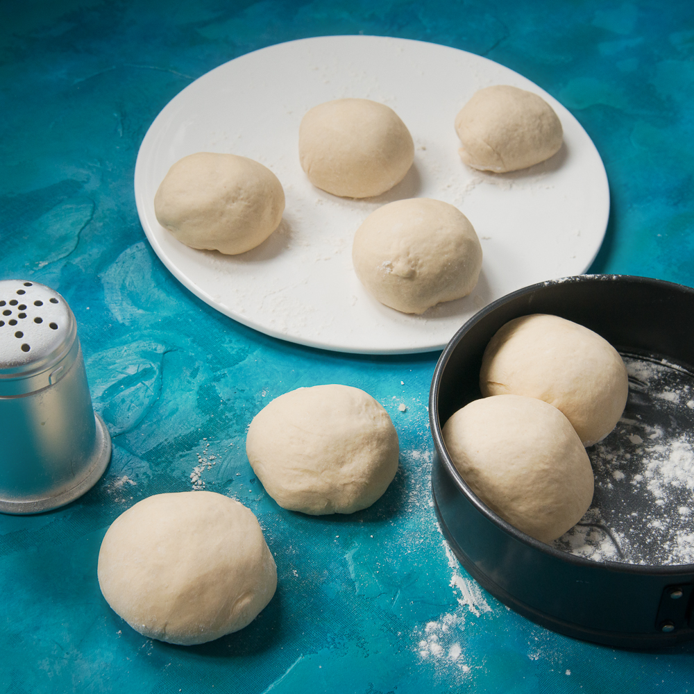 Dough balls on a plate and in a baking tray