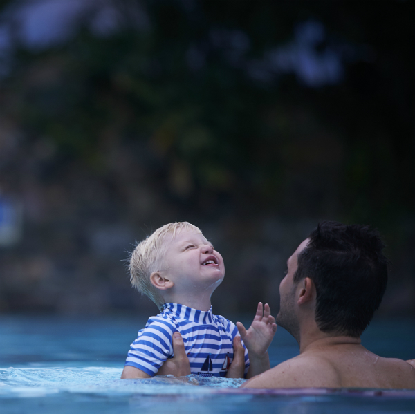 Man holding child in pool