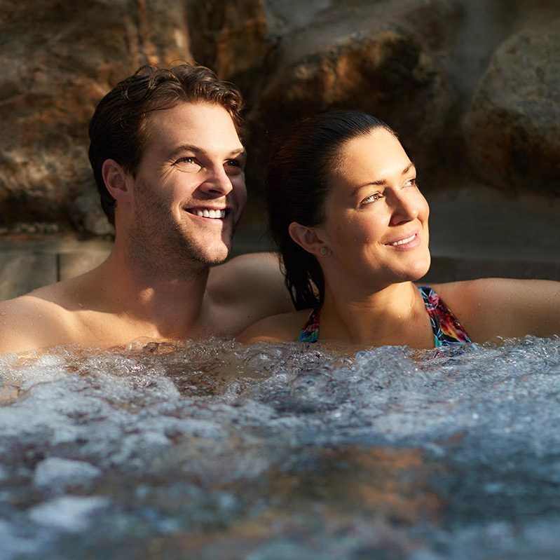 Couple sat in a whirlpool looking into the distance