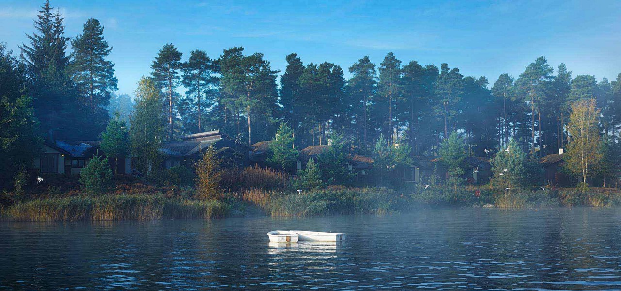 Whinfell lake on a misty morning with lodges and trees in the distance