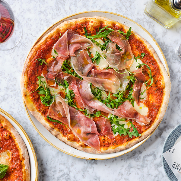 Pizza topped with rocket and Parma ham