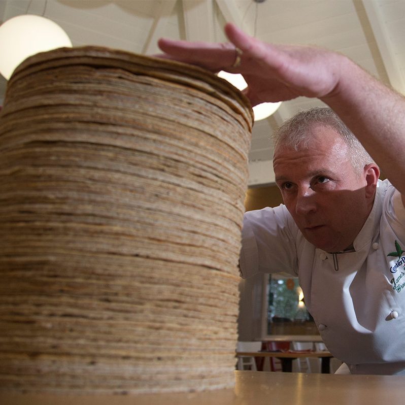 James Haywood adding a pancake to the pancake stack to break the world record for the tallest stack of pancakes.