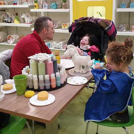 Emma and her family at pottery painting