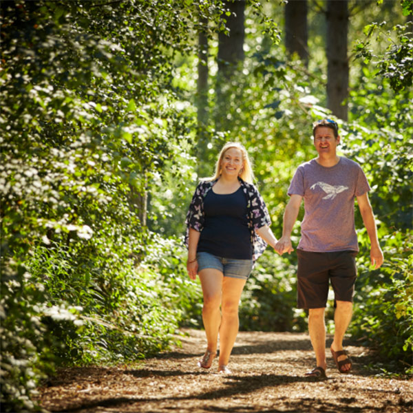 Couple walk through forest