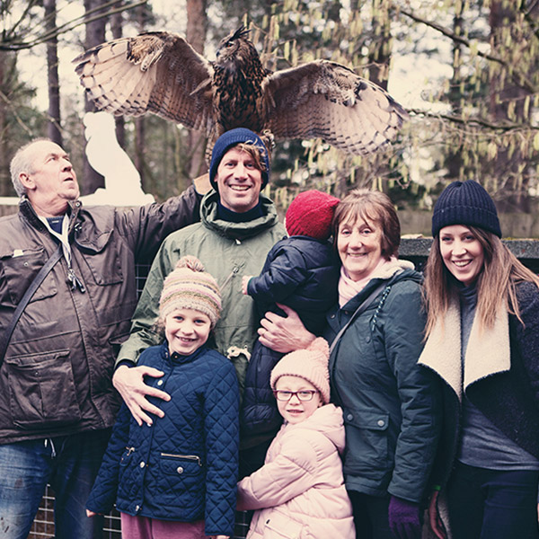A family posing in front of an owl.