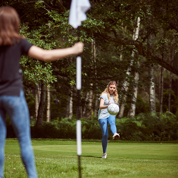 Girl kicks ball in game of Foot golf