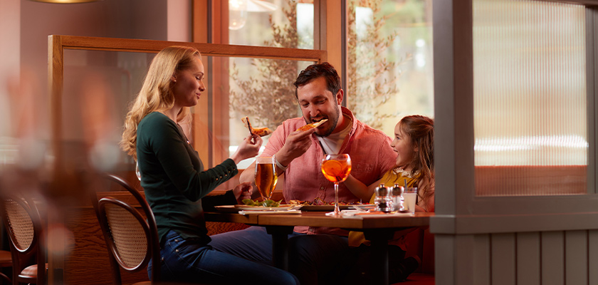 A family sat at a restaurant eating pizza.