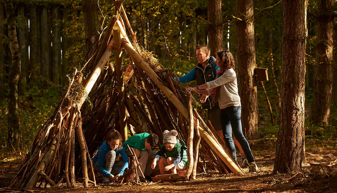 A family building a den out of twigs and sticks.